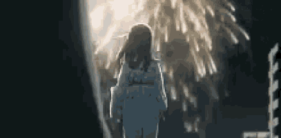 a girl is walking in front of a fireworks display .