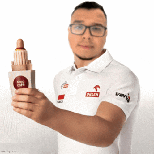 a man in a stop cafe shirt is holding a hotdog