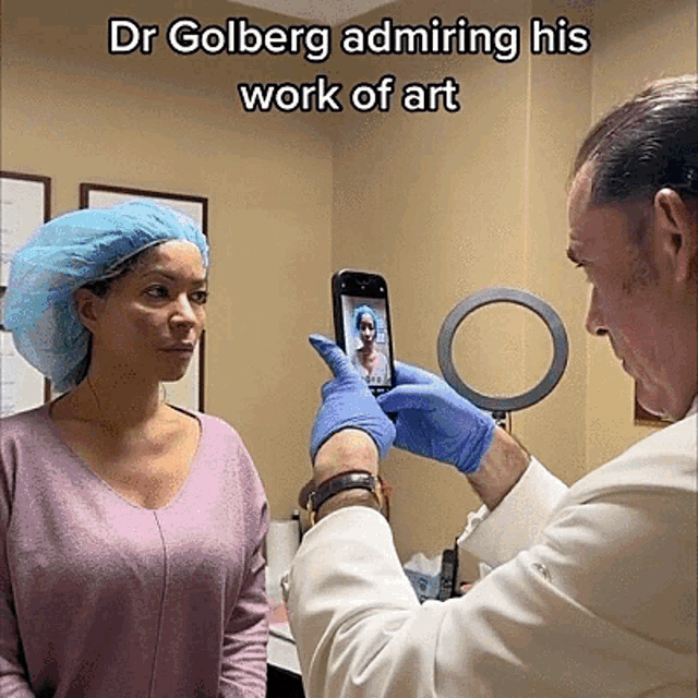 a doctor is taking a picture of a patient 's face with the caption dr golberg admiring his work of art