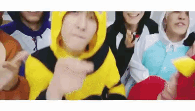 a group of people wearing costumes are standing next to each other and making funny faces .