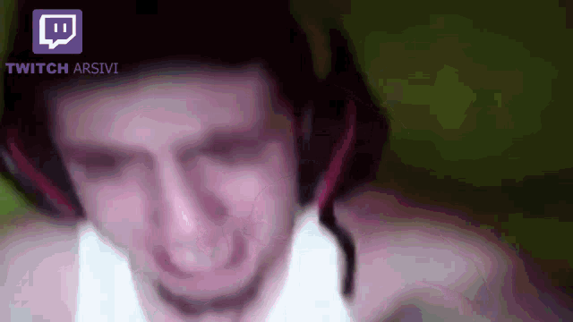 a blurry picture of a man wearing headphones and a twitch app icon
