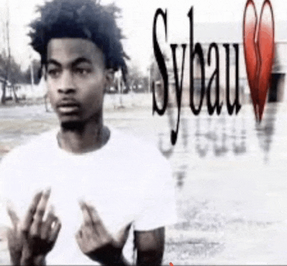 a young man in a white shirt is giving the middle finger in front of sybau