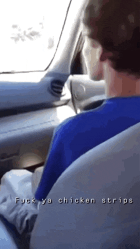 a man in a blue shirt is driving a car with the words " fuck ya chicken strips " on the bottom