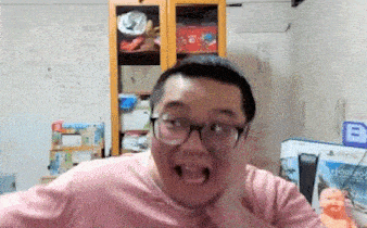 a man wearing glasses is making a funny face in a room .