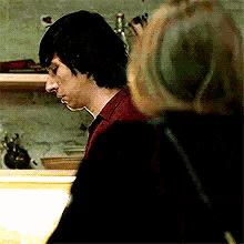 a man in a red shirt is looking at a woman in a black shirt