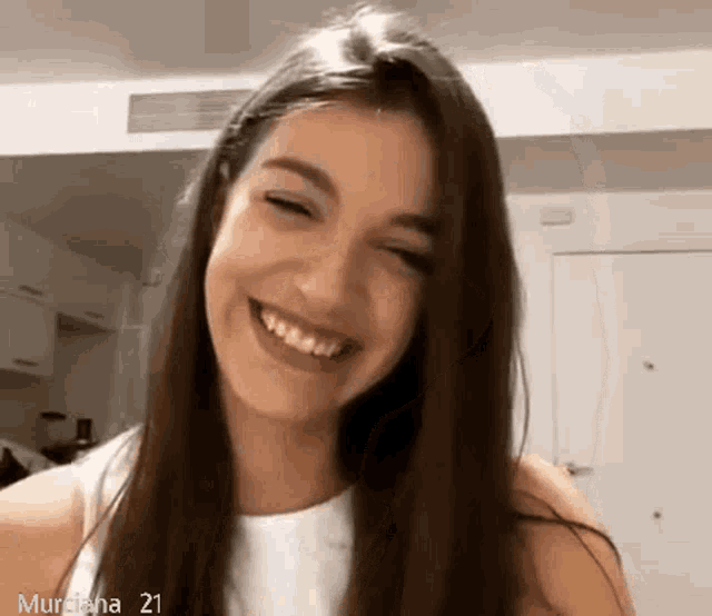 a woman with long hair is smiling with the number 21 on the bottom