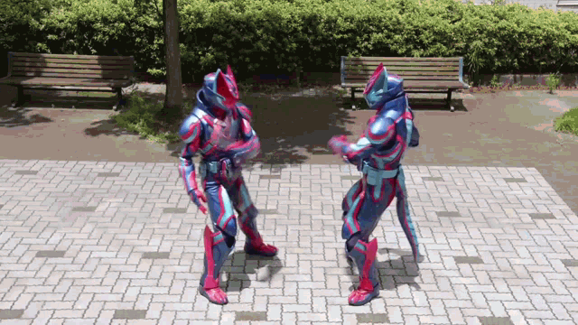 two superheros are standing on a brick sidewalk