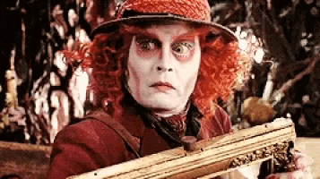 a man with red hair and a hat is holding a gun .