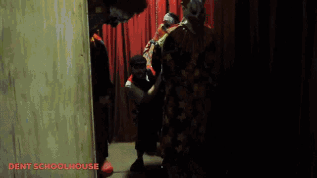 a group of people are standing in a dark room with the words dent schoolhouse written on the bottom