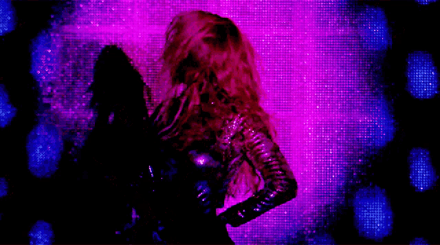 a woman in a sequined dress is standing in front of a purple background