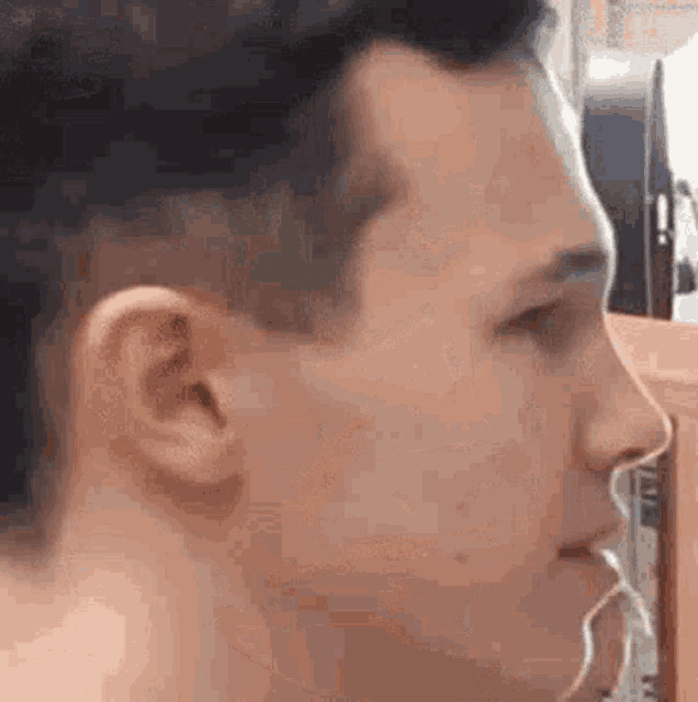a close up of a man 's face with a pair of ear buds in his ear .