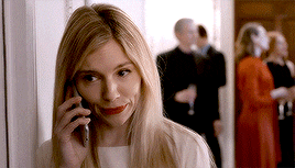 a woman in a white dress is talking on a cell phone