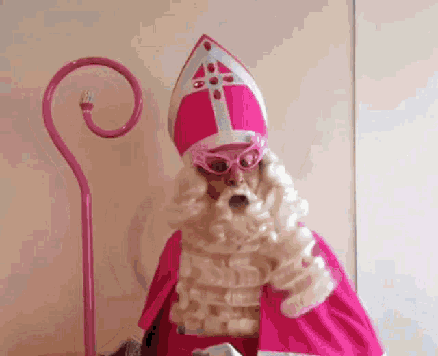 a man in a pink and white costume with a cane