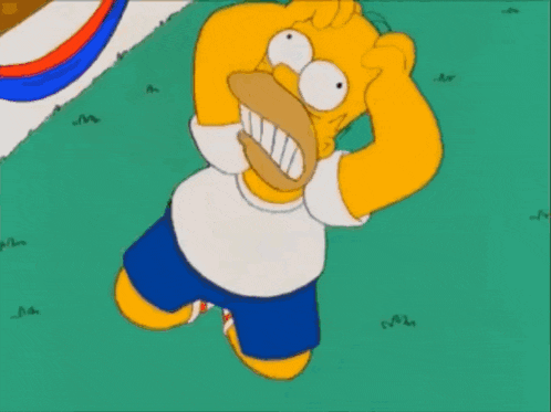 homer simpson is laying on the grass with his mouth open and his hands on his head