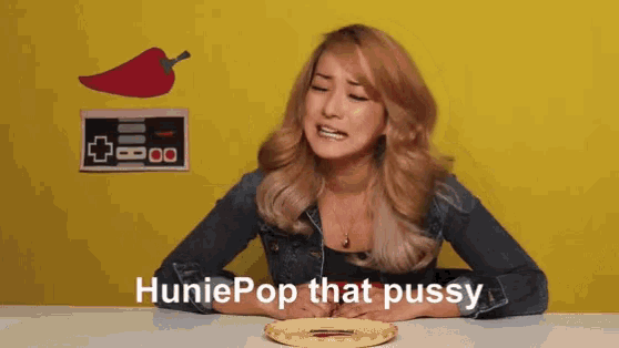 a woman sitting at a table with the words huniepop that pussy written on her face