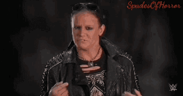 a woman in a black leather jacket with spikes on the collar