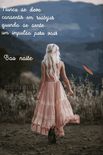 a woman in a pink dress stands in a field