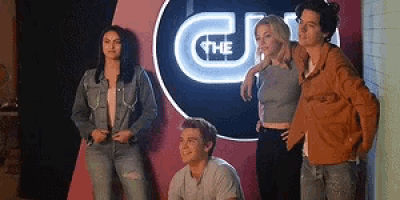 a group of people standing next to each other in front of a sign .