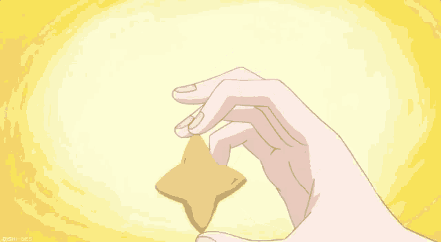 a person is holding a cookie in the shape of a star .