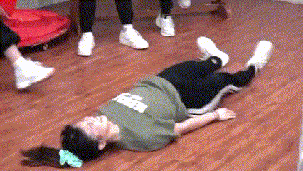 a woman is laying on her stomach on a wooden floor with her legs crossed .