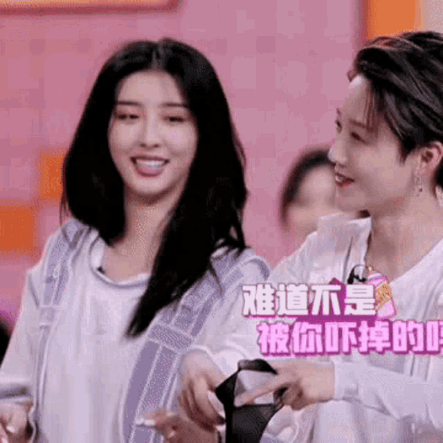 two women are standing next to each other and smiling .