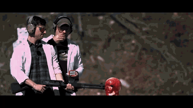a man wearing a hat that says ' army ' on it holds a gun