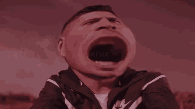 a man wearing a nike jacket has his mouth open