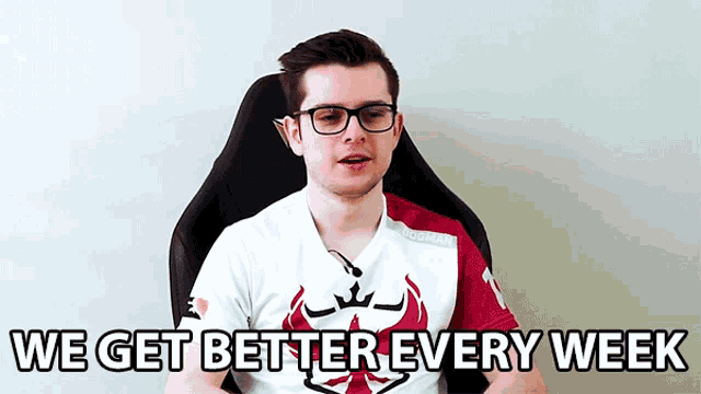 a man wearing glasses is sitting in a chair with the words `` we get better every week '' written on the screen .