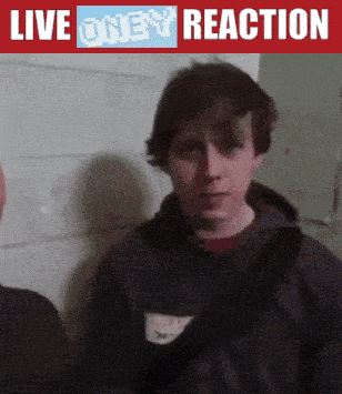 a man is standing in front of a live oney reaction sign