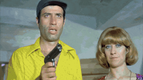a man in a yellow shirt is holding a gun