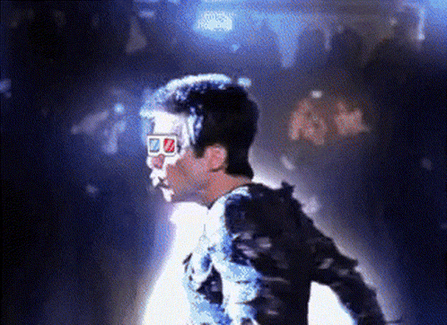 a man wearing a pair of 3d glasses is standing in the dark