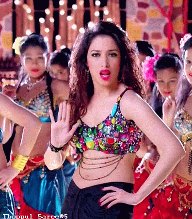 a woman in a colorful crop top stands in front of a group of dancers with thoppul saree95 written on the top