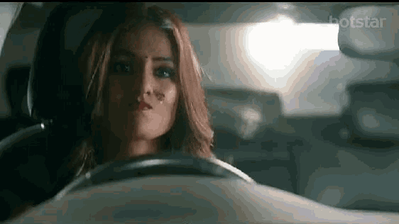 a woman is driving a car with a tattoo on her face .