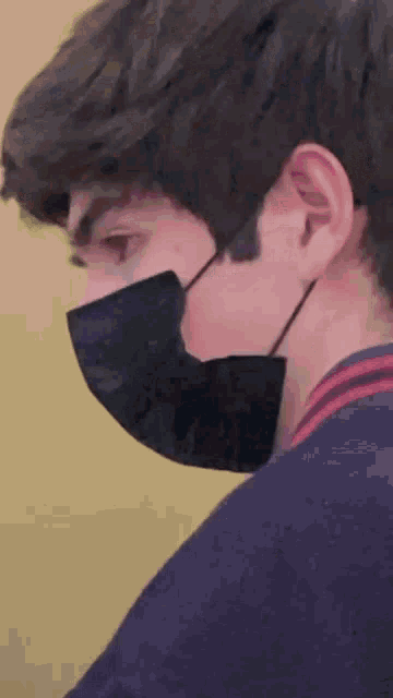 a close up of a person wearing a black mask .