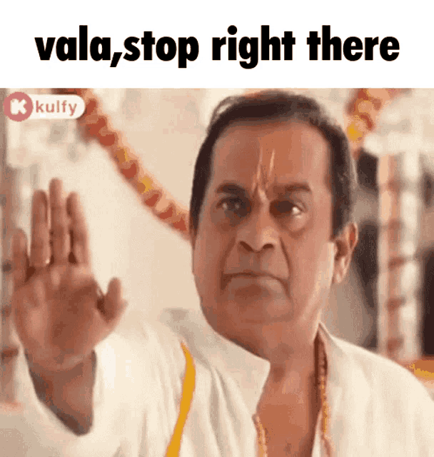 a man in a white shirt is making a stop gesture with his hand .