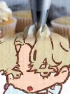 a close up of a drawing of a person 's face on a piece of cake
