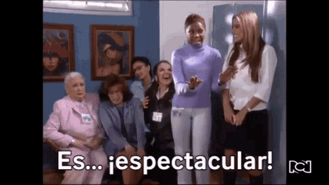 a group of women are standing next to each other in a room with the words " es ... espectacular " written on the screen .
