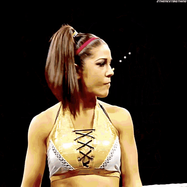 a female wrestler stands in a ring with the nextbigthing written on the bottom right