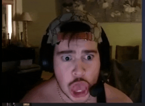 a shirtless man wearing headphones and a hat is making a surprised face