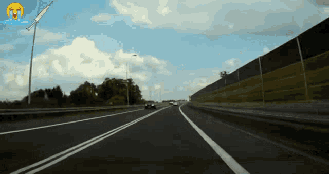 a car driving down a highway with a smiley face on the windshield