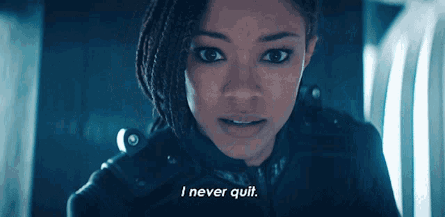 a woman says " i never quit " in front of a dark background