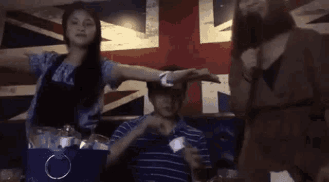a group of people are standing next to each other in front of a british flag and singing into microphones .
