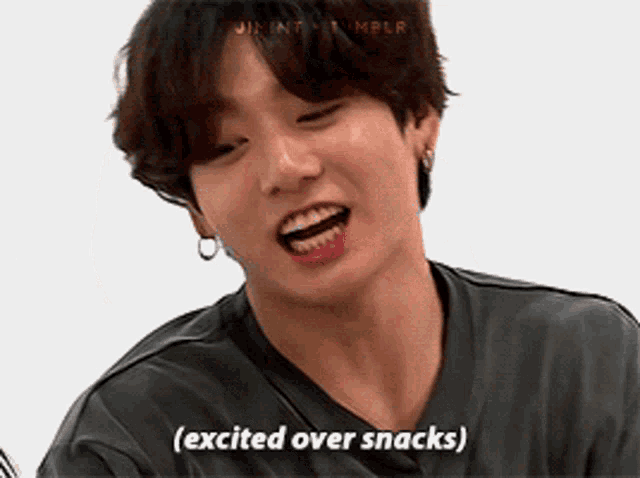 a young man says excited over snacks in front of a white wall