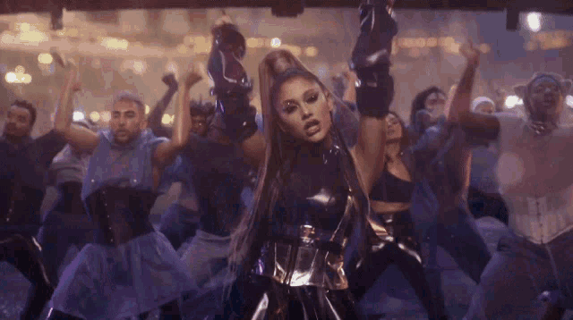 ariana grande is dancing in front of a crowd of dancers