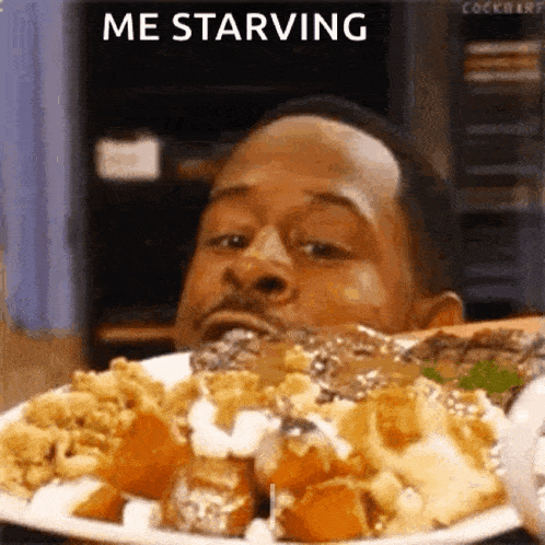 a man is eating a plate of food and says `` me starving '' .
