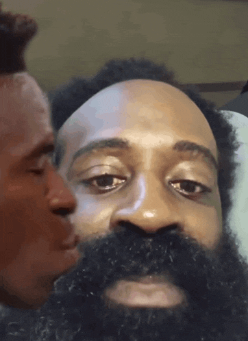 a man with a beard is looking at another man