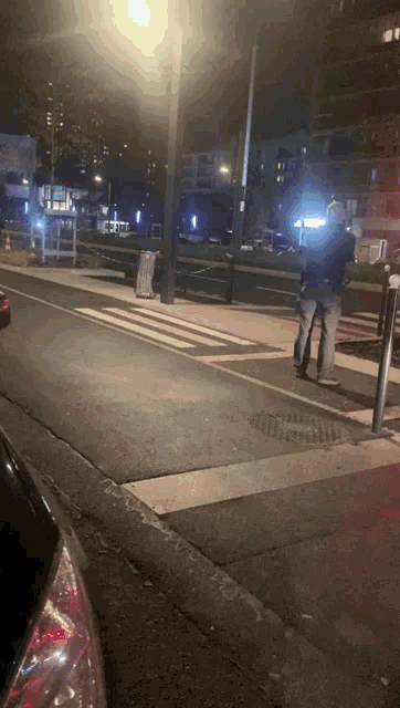 a person walking down a street at night with a sign that says ' a ' on it