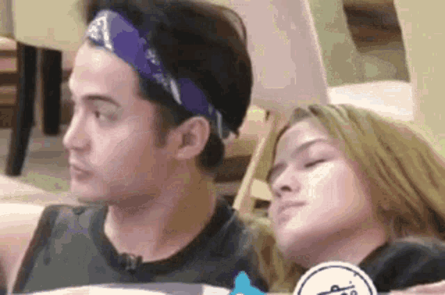 a man and a woman are sitting next to each other in a room .
