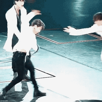 a blurry photo of two men dancing on a stage with the words skiosim visible