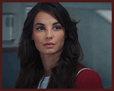 a woman with long dark hair looks at the camera